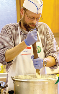 Daniel Beers, assistant professor of political science, mashes potatoes for a KPCK dinner in the basement of Galesburg's Central Congregational Church.
