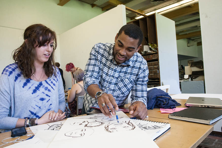 Artist in Residence Mario Moore talking with a Knox College student in his painting class.