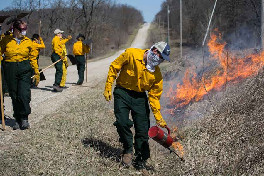 Knox College students help with the traditional springtime prairie burn at Green Oaks Biological Field Station. Controlled fire ensures the health of the prairie.