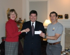 President Taylor accepts a check from Doug '66 and Maria Bayer.