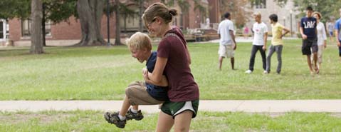 A Knox student enjoys the weather and her family on the Knox campus.