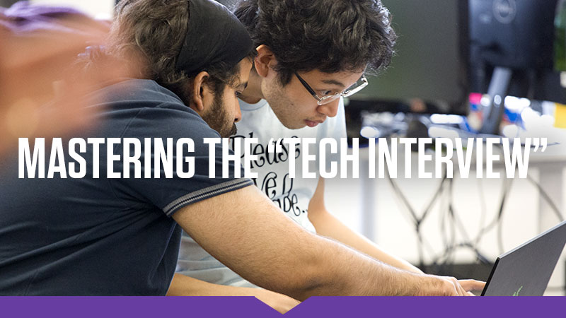 "Mastering the 'Tech Interview'": A pair of young men in t-shirts crouch together over a laptop.