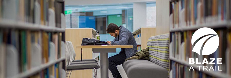 A Knox College student studies in Amott Commons