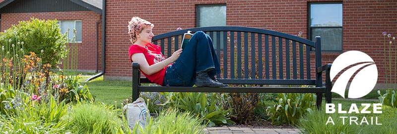 A Knox College student studies outside the residence halls
