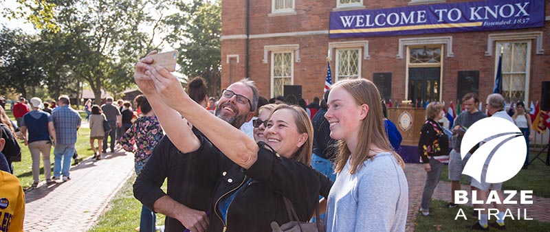 A new Knox College student takes a photo with her parents at New Student Orientation