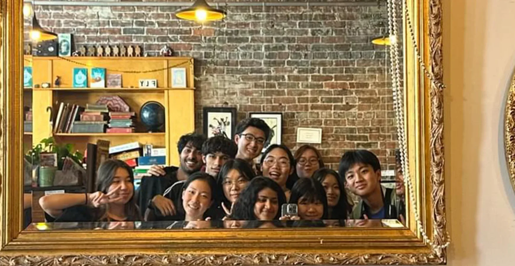 students taking a mirror selfie at the beanhive (coffee place)