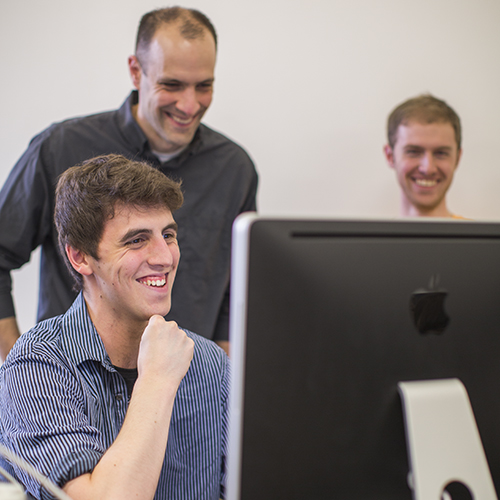 A professor and students analyze results in a biology lab.