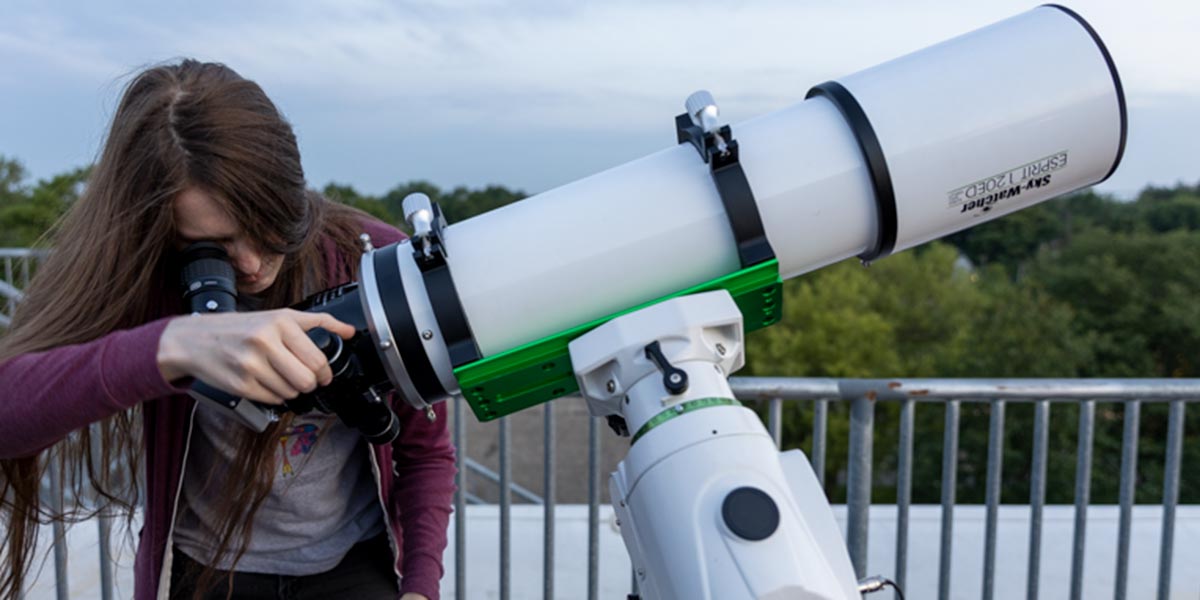 A student looking through a telescope at the observatory.