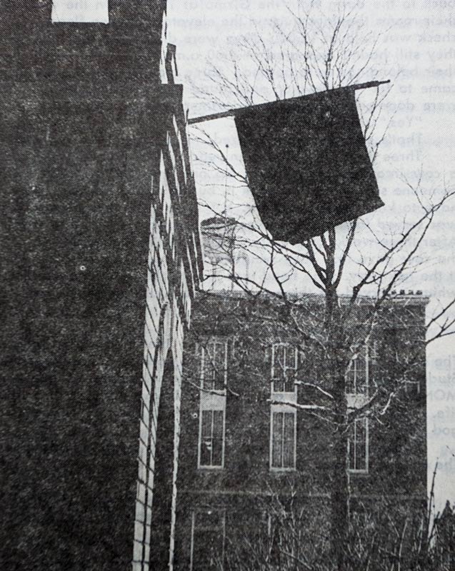 Photo of black flag on the brick tower.