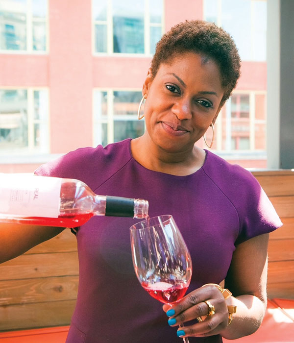 Regine Rousseau pours a glass of wine.