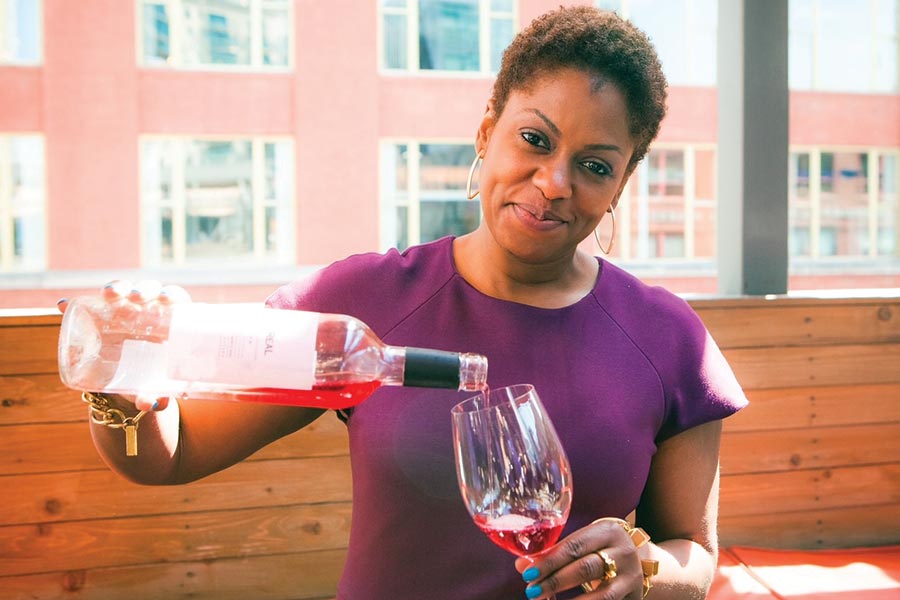 Regine Rousseau pours a glass of red wine.
