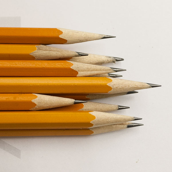 A pile of sharpened pencils sit on a table.