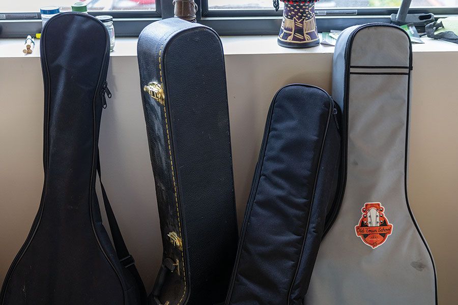 Different instruments in cases sit against the wall.