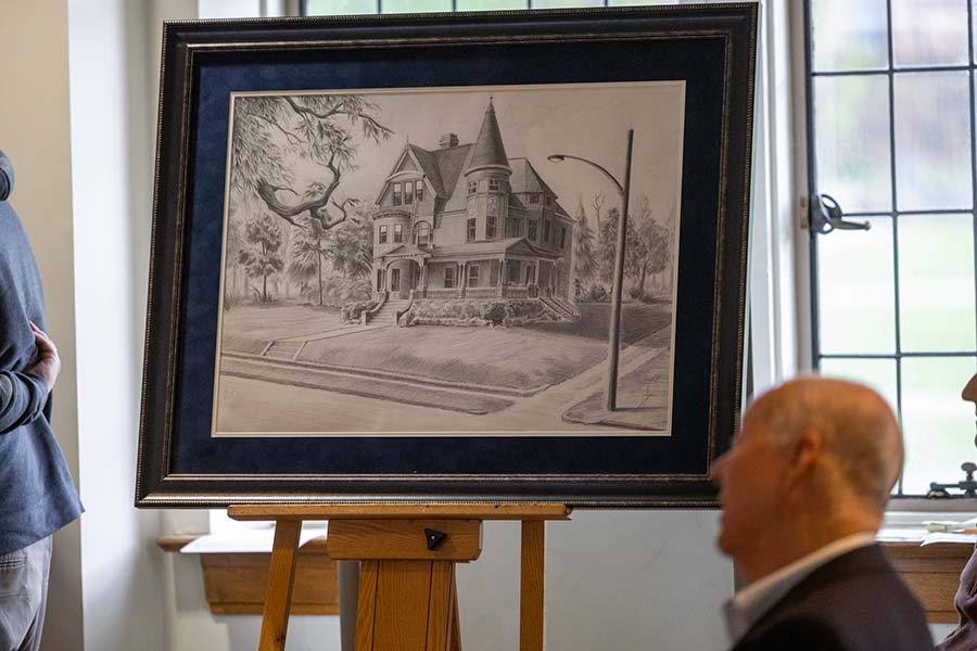 A framed drawing of the Anderson House sits on a easel for viewing.