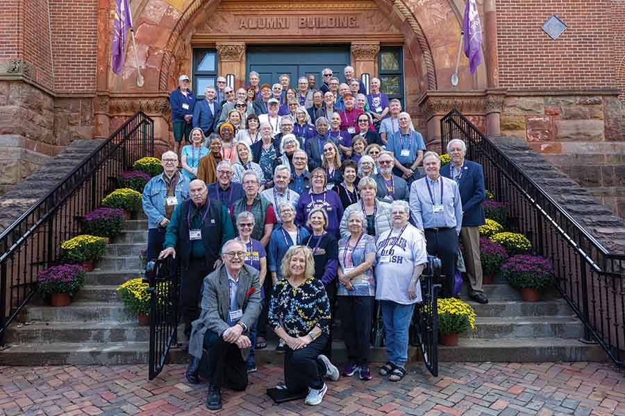 The Class of 1975 stands on the steps leading up to the Alumni Building, posing for a photo.