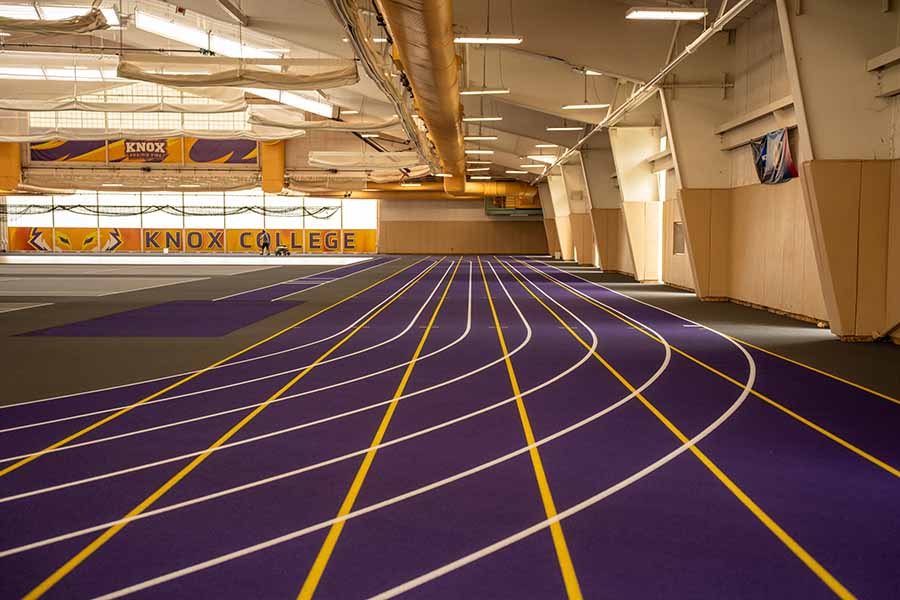 Resurfacing of the T. Fleming Fieldhouse shows a purple surface with white and gold lines creating the lanes on the track.