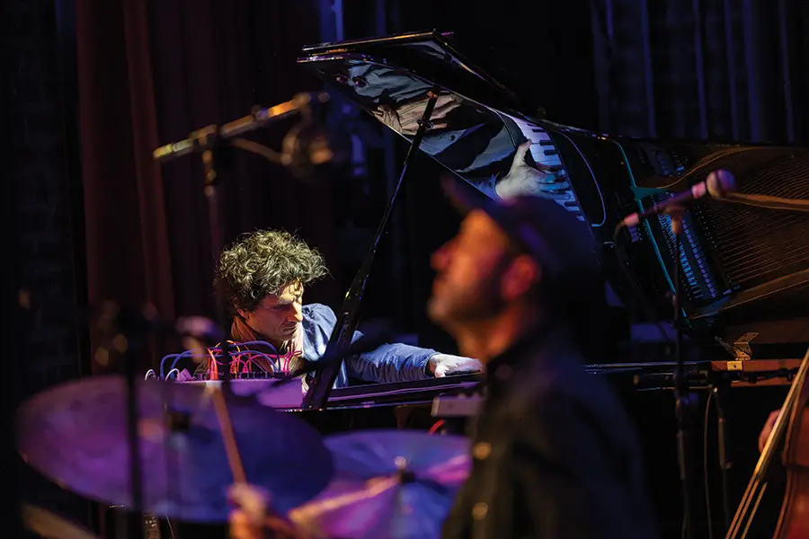 Pianist Romaine Collin is reflected in the lid of his of his instrument