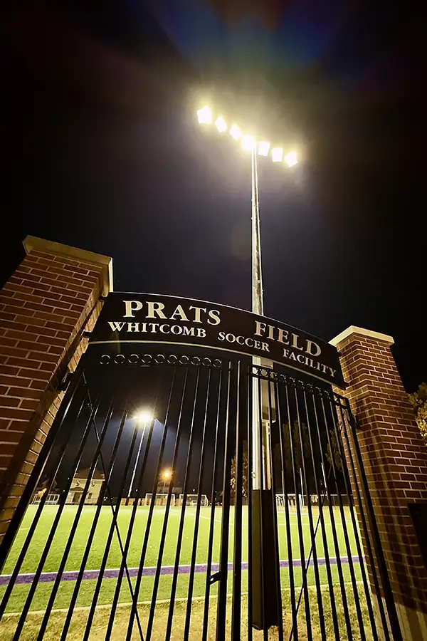 Lights illuminate the soccer field at night.