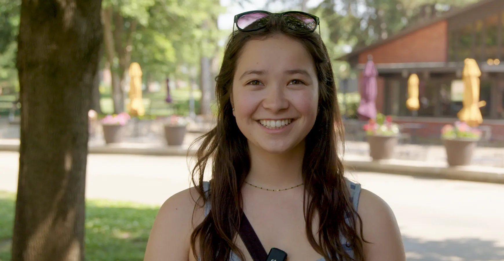A student smiles at the camera with the Gizmo patio in the background.