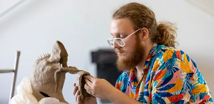 A student works on a sculpture in the Whitcomb Art Center. 