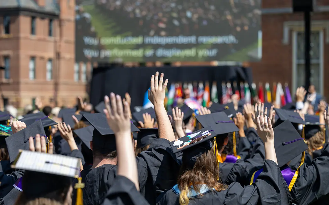 Knox graduates raise their hands during their Commencement ceremony.