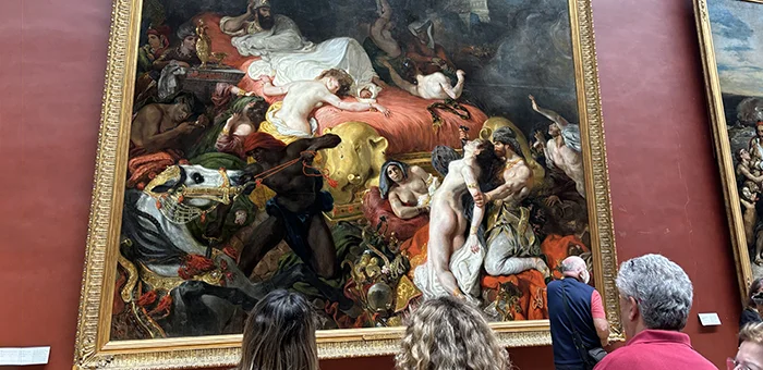 At the Louvre Museum in Paris, students look up at Eugène Delacroix's famous painting, The Death of Sardanapalus.