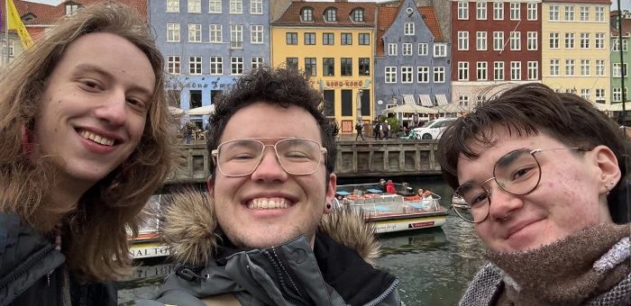Three students take a selfie in front of the the iconic Nyhavn harbor in Copenhagen, Denmark.