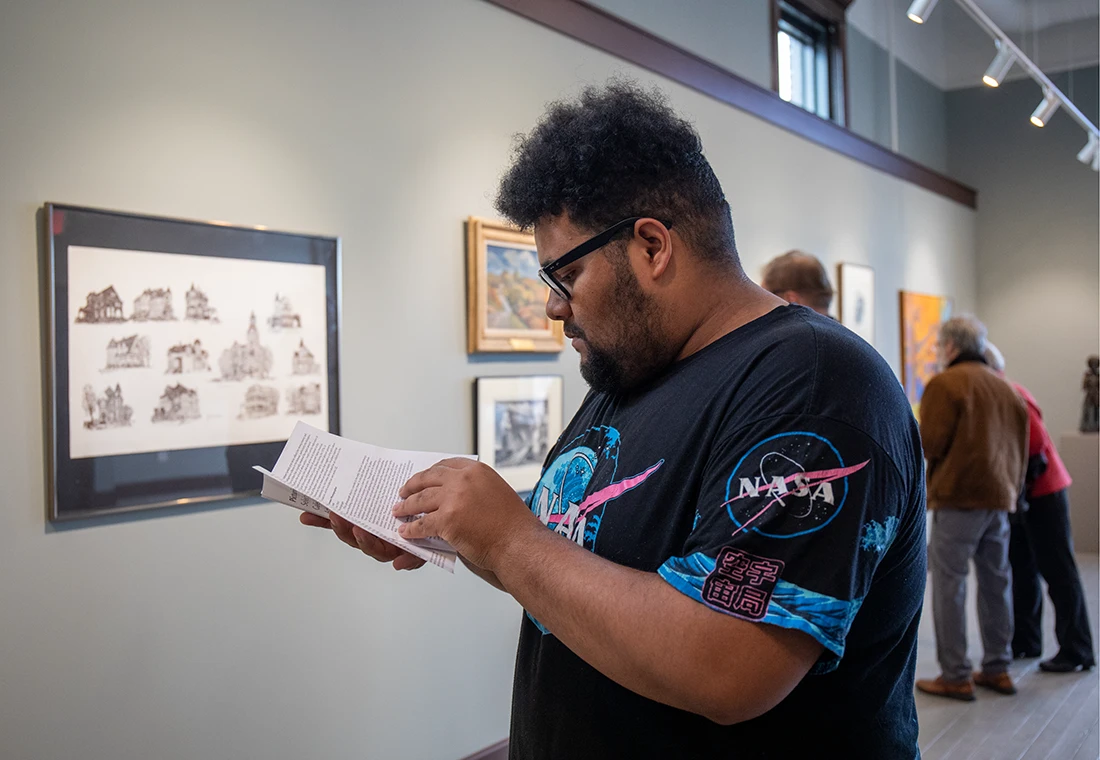 A student walks through an exhibit in an art gallery.