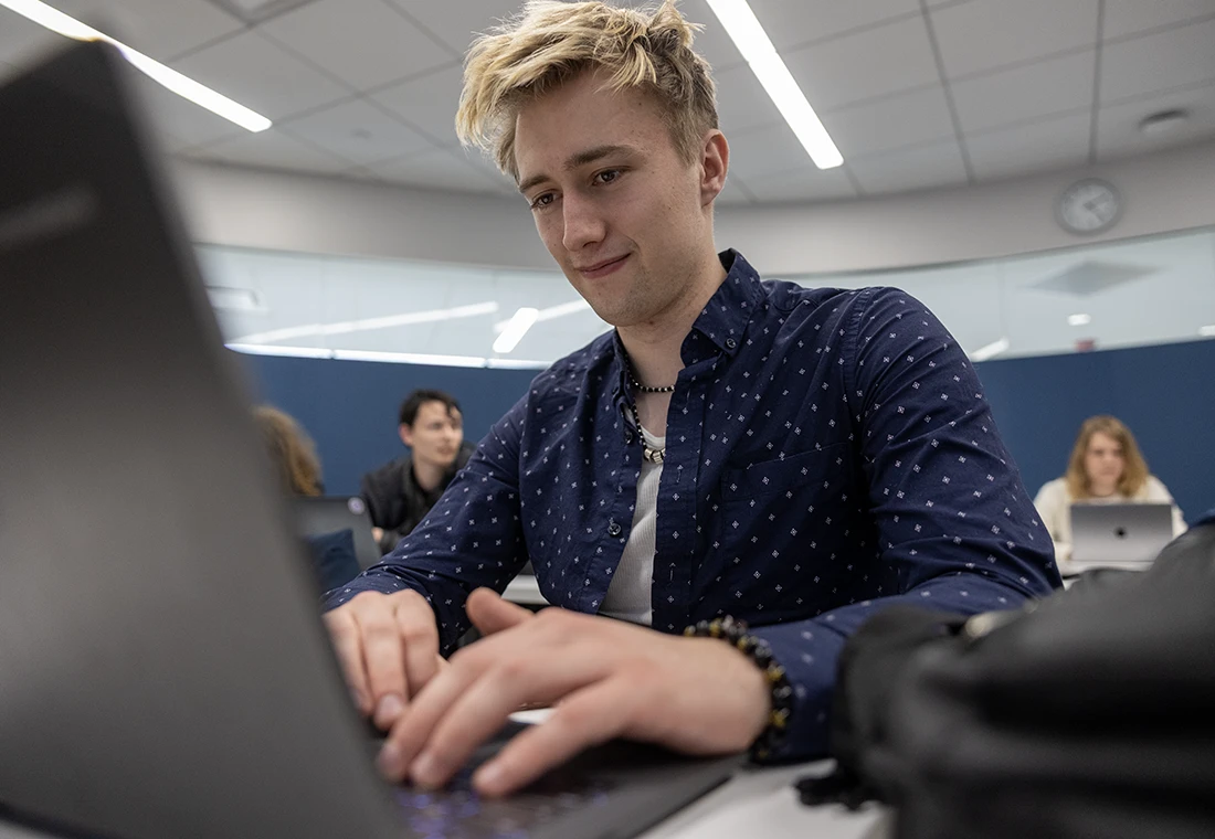 A student in gamer class works on a laptop computer.