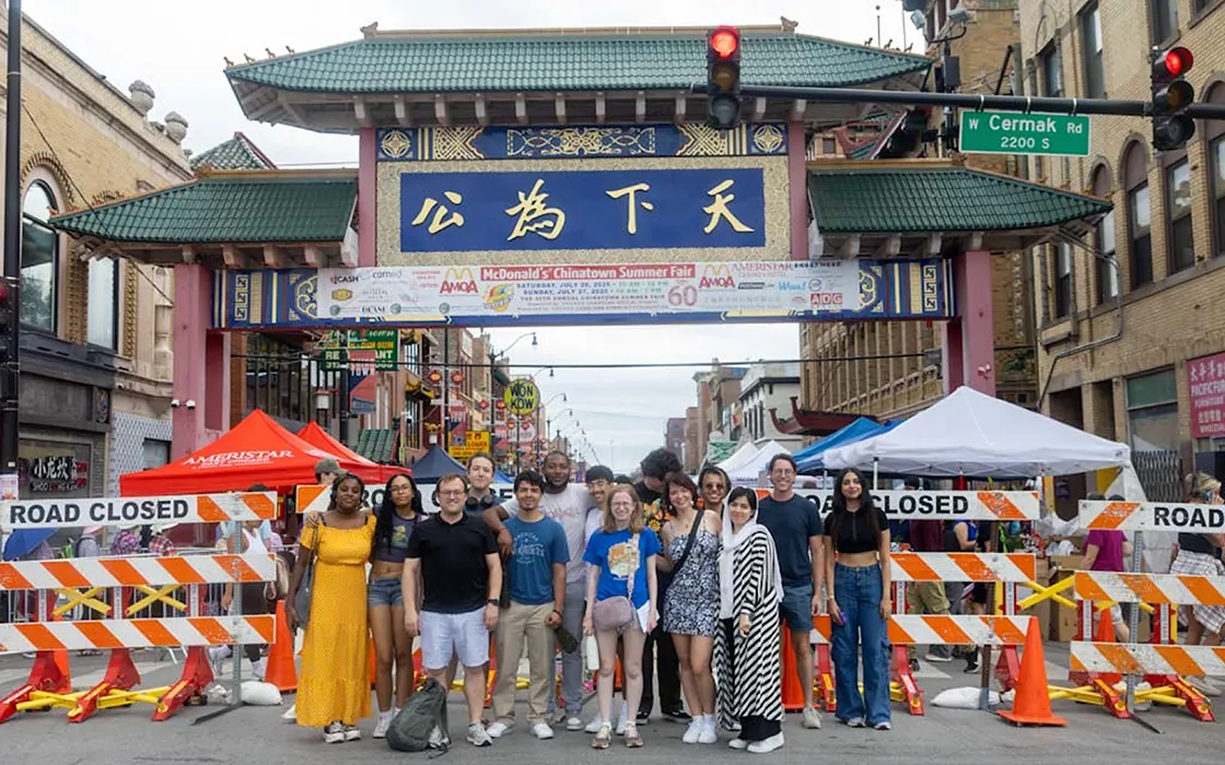 A group of students stands in front of the entrance of Chinatown in Chicago, Illinois, smiling at the camera.