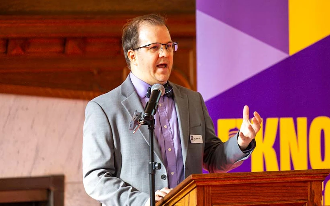 Tom Bazan ’05 speaks at a podium during the Knox College 2024 Alumni Achievement Awards Ceremony.