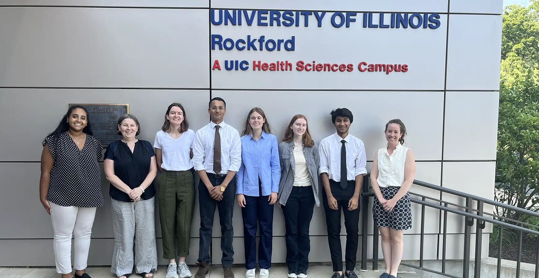 A group of students standing in front of the University of Illinois Rockford sign