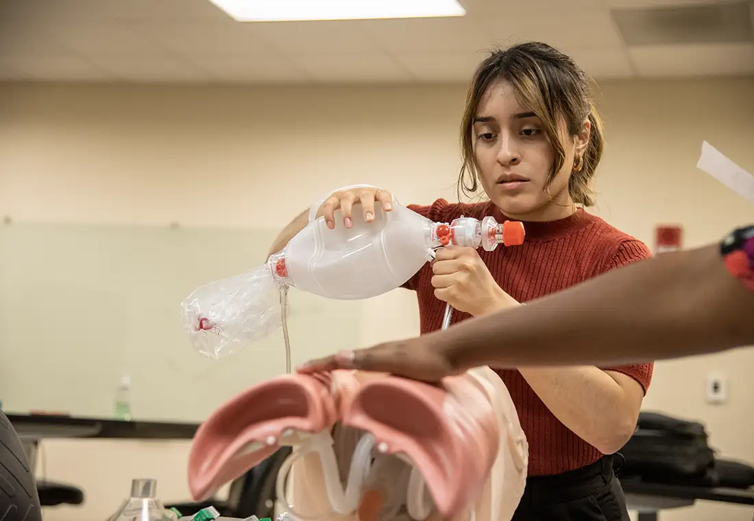 A student works on a CPR doll.