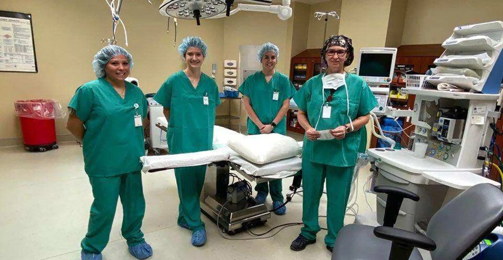 A surgical team stands in a surgical room.