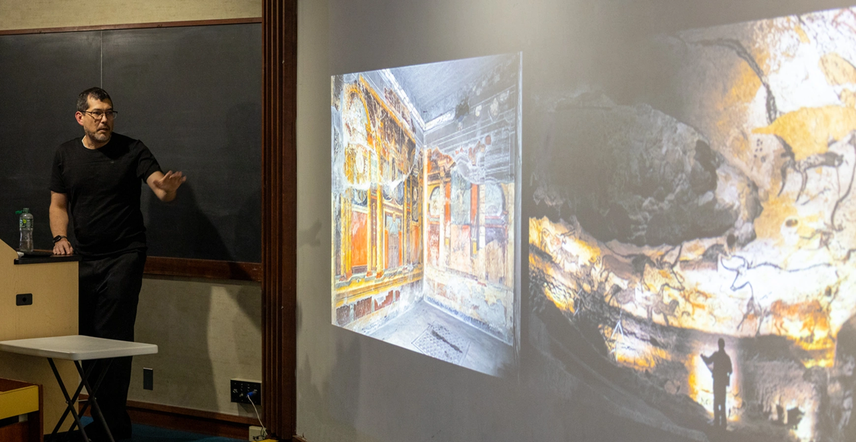 A man presents images of art on a screen.
