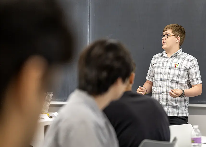 A student presenting at the front of the class.