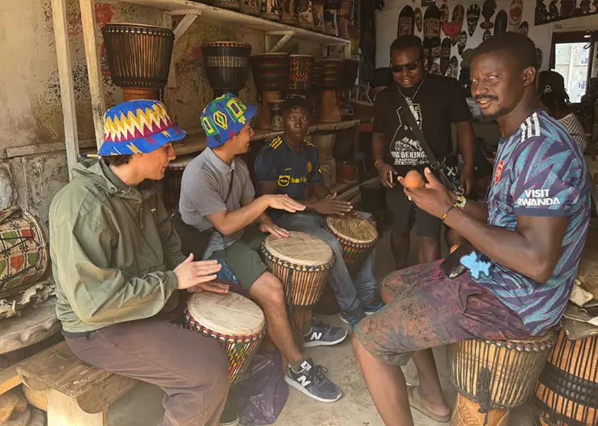 Knox students playing the drums with locals in a study abroad program.