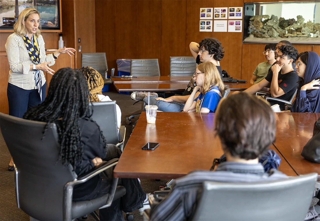 Students sit in a conference room listening to an alum in Chicago.