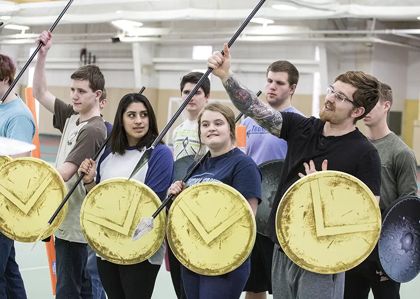 A class stands together with shields they created.