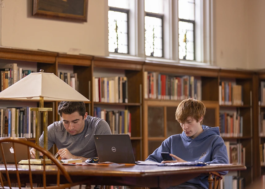 Two students study at a table in the Red Room of the Seymour Library.