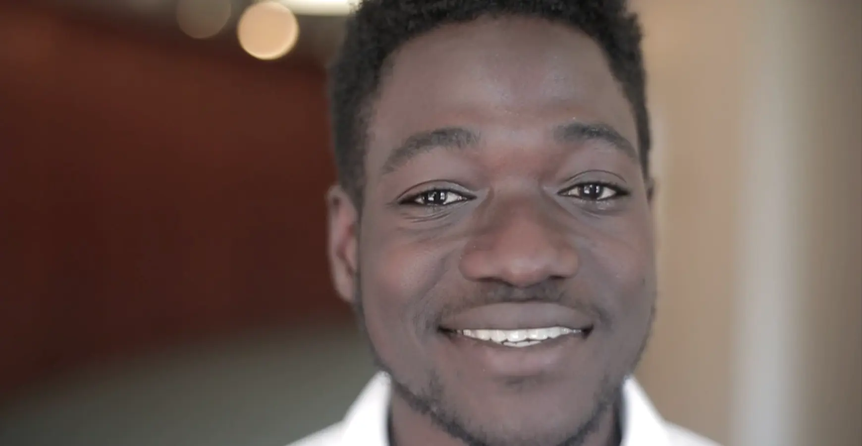 A Knox student smiles directly into the camera. Their face is centered in the iamge. 