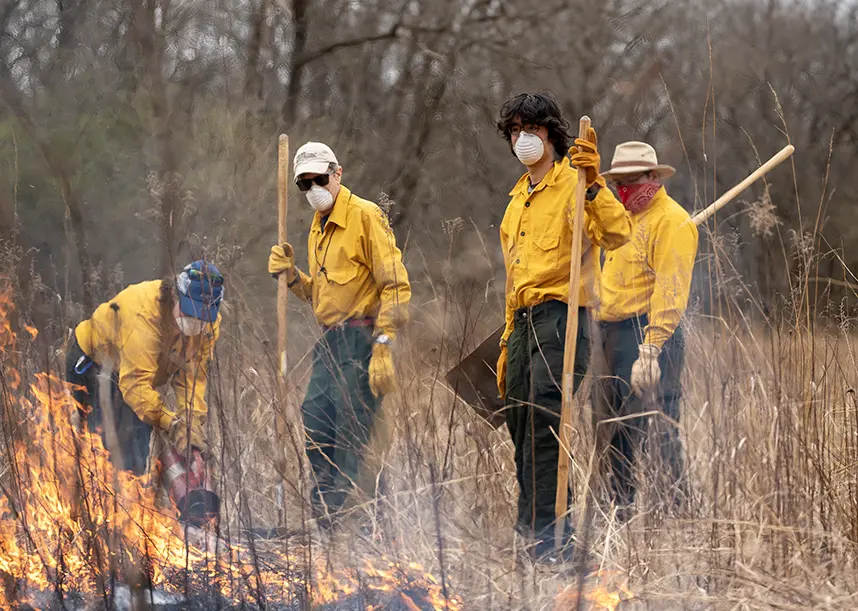 Students working with a professor during a prairie burn.
