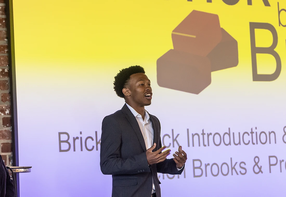 A student presenting in front of a screen