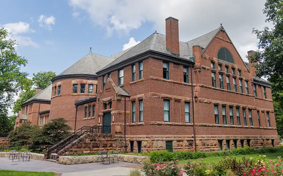 Alumni Hall on a sunny day with blue skies and clouds in the background.
