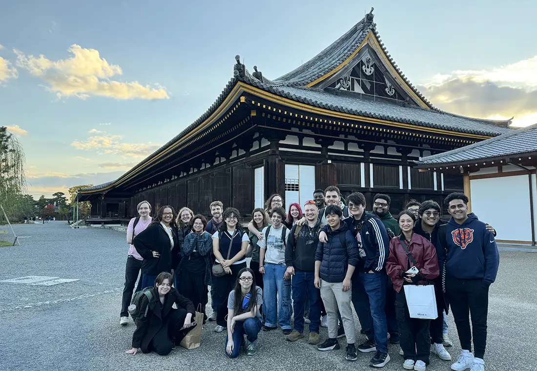 Group of students standing outside a traditional building in Japan.