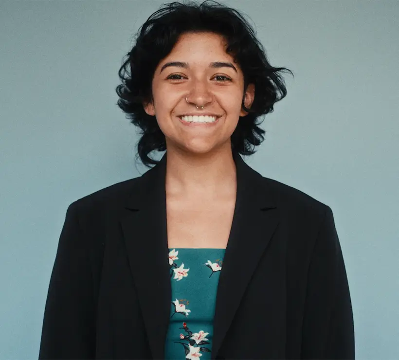 Headshot of Esme Garcia smiling at the camera with a gray backdrop. 