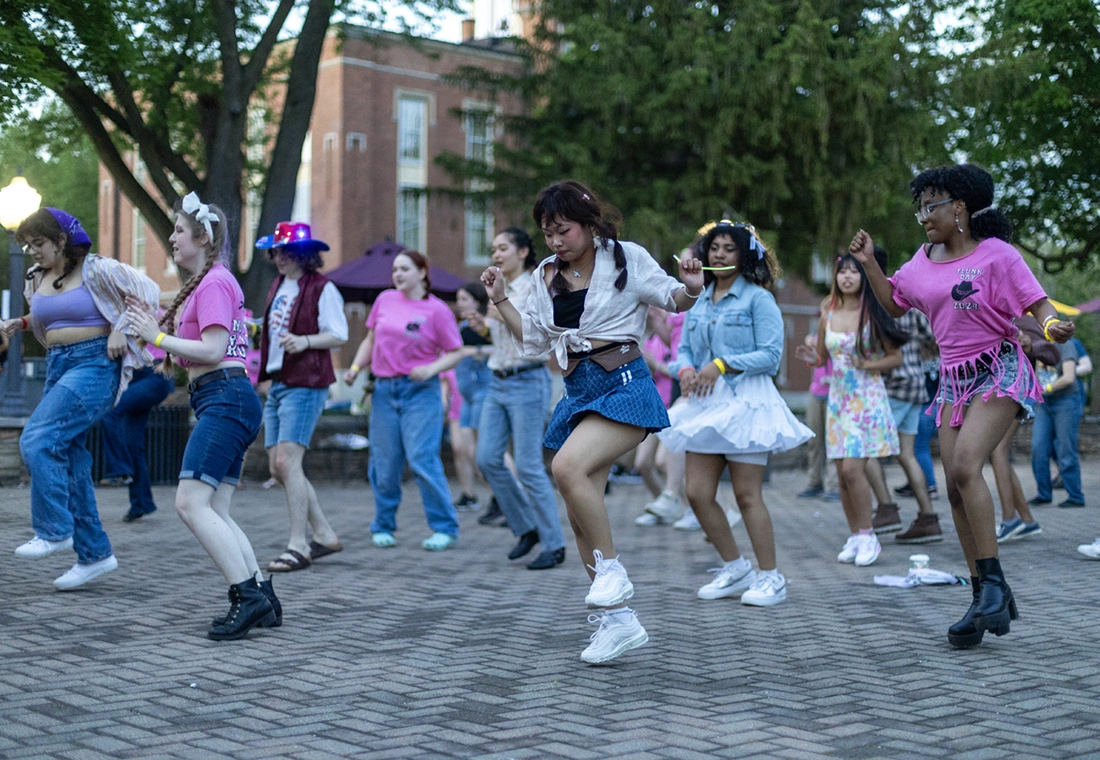A group of students dance on a patio on campus during Flunk Day 2024.