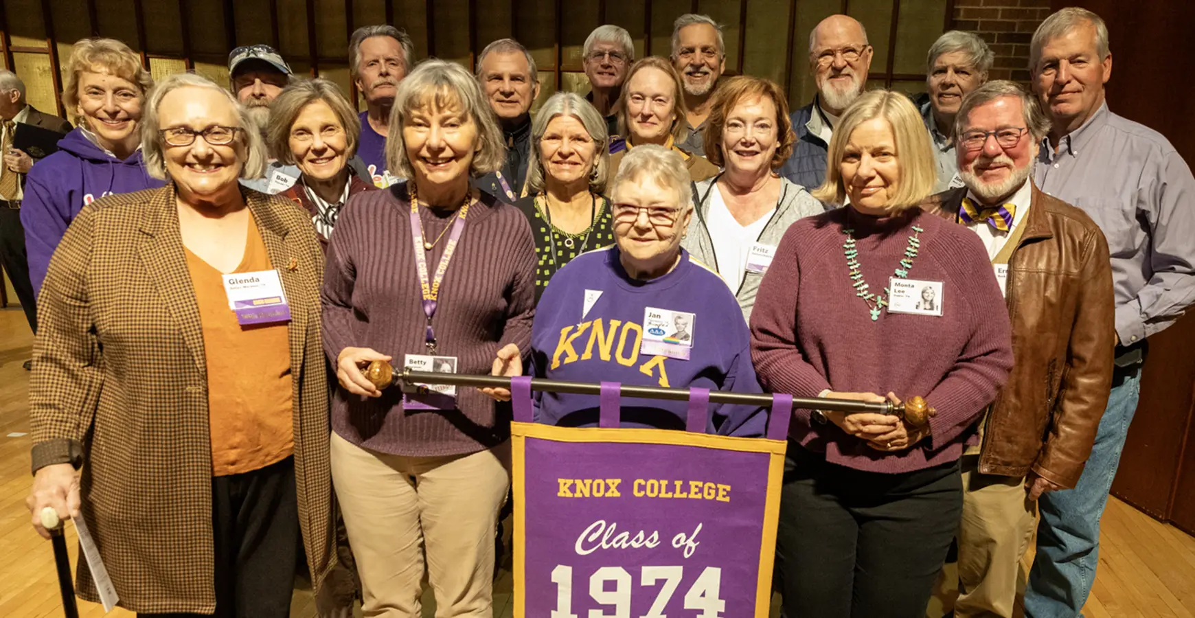 The Class of 1974's reunion photo. Members of the class stand in four rows; the first row holds a banner that says "Class of 1974."