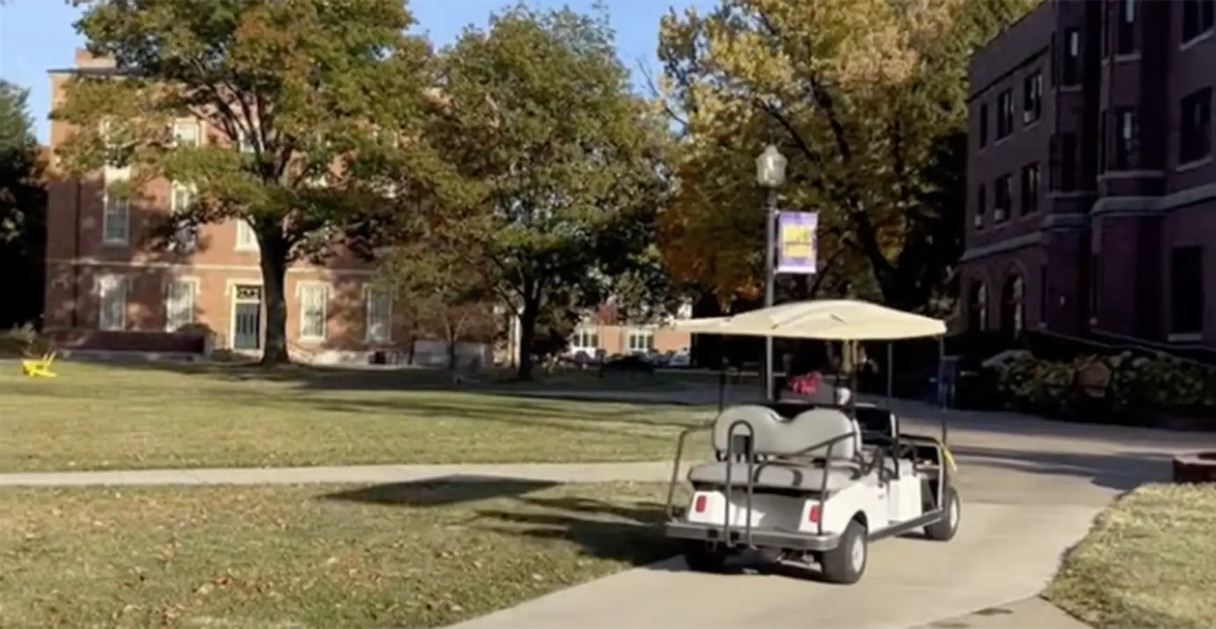 A golf cart drives across the Knox campus on a fall day.