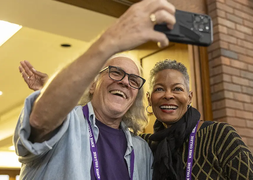 Two Knox alumni smile and pose side-by-side for a selfie.